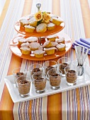 Chocolate mousse in glasses, muffins on tiered stand