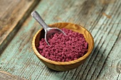 Acai powder (diet aid) in small wooden bowl with scoop