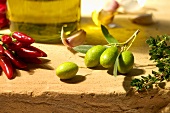 Stillleben mit Oliven, Peperonicini und Kräuter