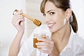 Young woman with honey and honey dipper