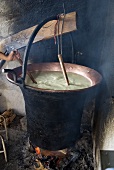 Making ricotta: heating the whey in a copper vat