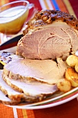 Roast pork with crackling, partly carved, with potatoes