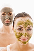 Two women with herbal and with healing clay facial masks