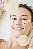 Young woman with lime slices on her face