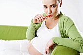 Pregnant woman eating a carrot