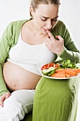 Schwangere Frau mit Gemüseteller
