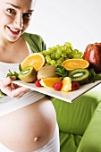 Schwangere Frau mit Obstteller