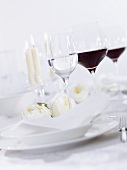 Glasses of red & white wine on table laid for special occasion