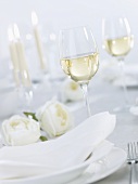 Glass of white wine on table laid for special occasion
