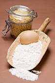 Flour and egg in old flour scoop, egg pasta in jar