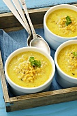 Three bowls of curried lentil soup on a tray