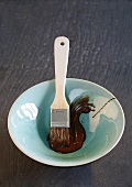 Melted chocolate couverture with brush in small dish