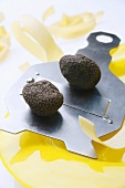 Black truffles (Chinese truffles) on truffle slicer, ribbon pasta