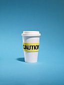 Cup of coffee with warning sign