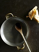 Frying pan with wooden spoon and Parmesan
