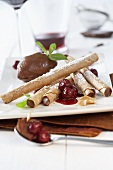 Wafer rolls with chocolate mousse and cherry sauce