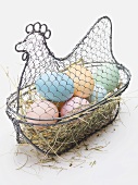 Easter eggs on hay in wire basket