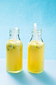 Pineapple and passion fruit juice with fruit in two bottles