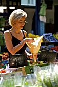 Blonde Frau beim Einkaufen auf einem Markt