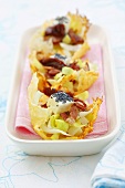 Chicory salad with feta, bacon, poppy seeds in Parmesan baskets