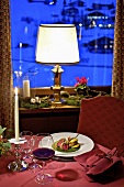 Winterlicher Tisch mit Lammgericht und Rotwein im Restaurant