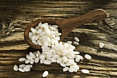 Grains of Avorio rice in wooden spoon and on wooden board