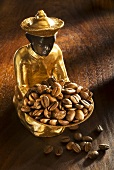 Gilded statuette with a bowl of coffee beans