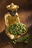 Gilded statuette with fresh green peppercorns