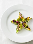 Salad star with edible flowers on plate