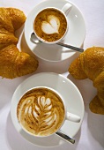 Espresso macchiato and cappuccino with croissants