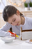 Girl making a gingerbread house for Christmas