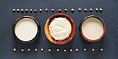 Soya milk and soya cream in small dishes with soya beans