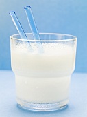 Milchglas mit blauen Strohhalmen