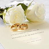 Wedding menu, wedding rings and white roses