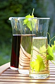 Wine in carafes on wooden table out of doors