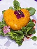 Deep-fried Camembert heart with corn salad and violets