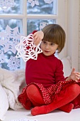 Girl playing with snowflake decoration