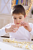 Boy threading popcorn (to make popcorn wreath)