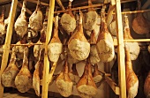 Raw hams hanging in maturing cellar of a ham factory