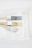 Paintbrushes with three different colours of paint on paper