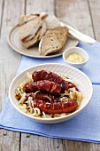 Sausages on onions with bread and mustard