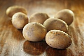 Several potatoes on wooden background