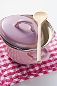 Pink pan with lid and wooden spoon