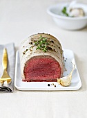 Rolled roast beef wrapped in pork fat