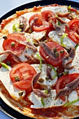 Pizza mit Tomaten, Kapern und Sardellen (ungebacken)