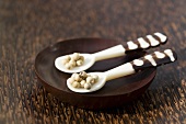 White peppercorns on two spoons