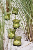 Candles in glasses in dunes