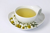 Cup of chamomile tea with fresh flowers