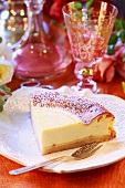 A slice of cheesecake with icing sugar