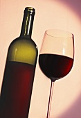 Ein Glas Rotwein mit Flasche